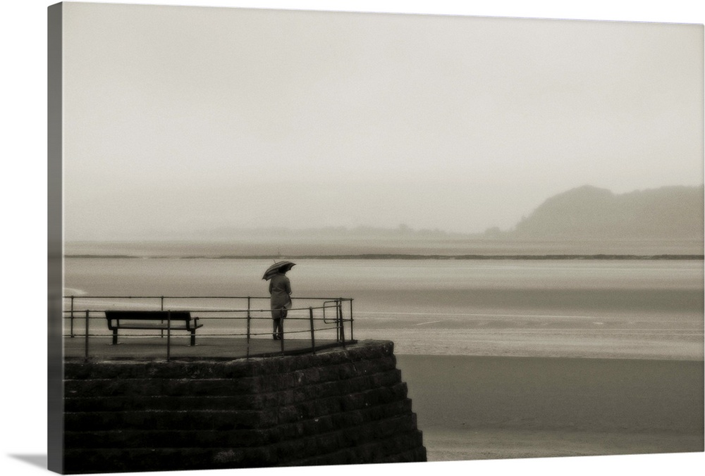 A woman standing all alone on a jetty
