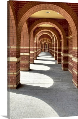 Looking along a line of brick archways with sunlight and shade