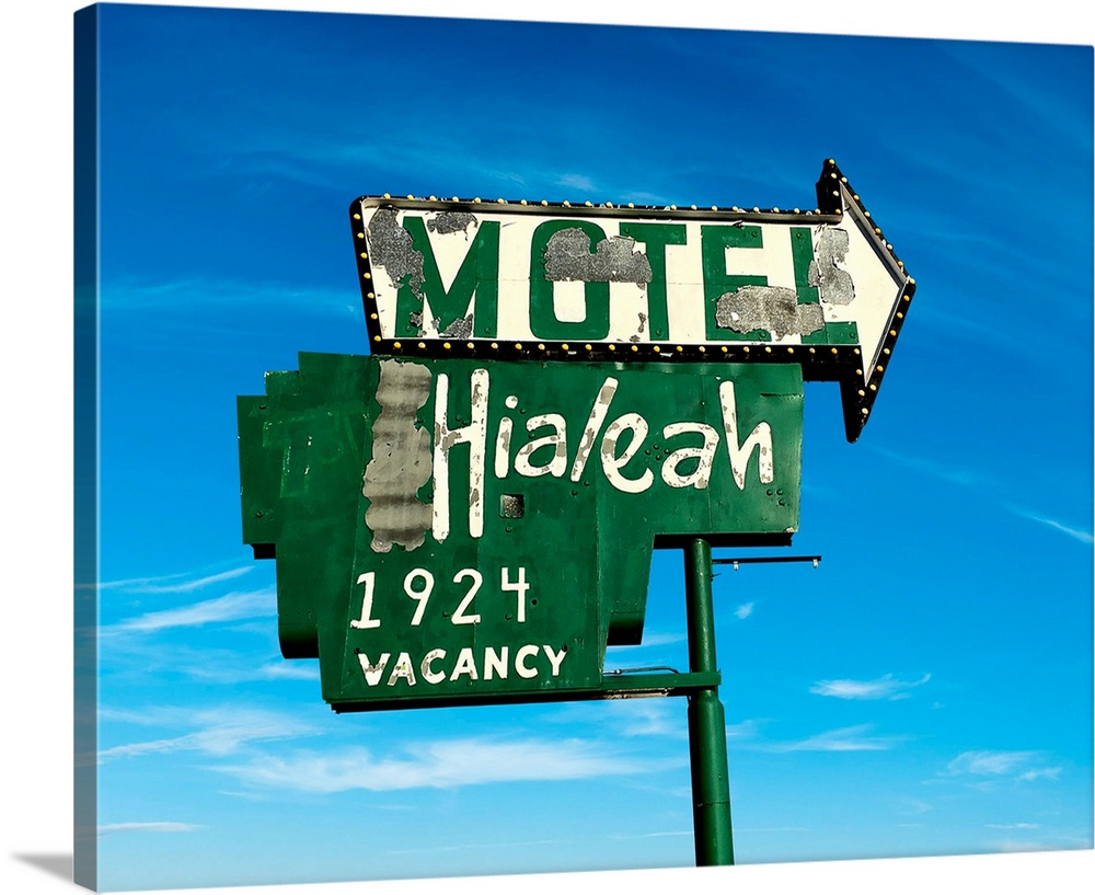 Old green street sign for a motel in USA.