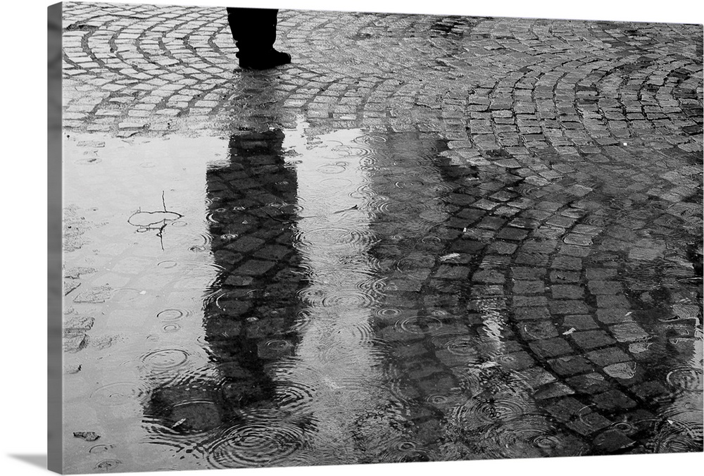The reflection of a woman with an umbrella, in black and white