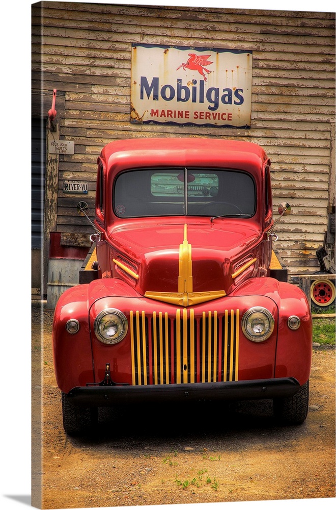 Classic old red truck parked in front of a Mobilgas sign.