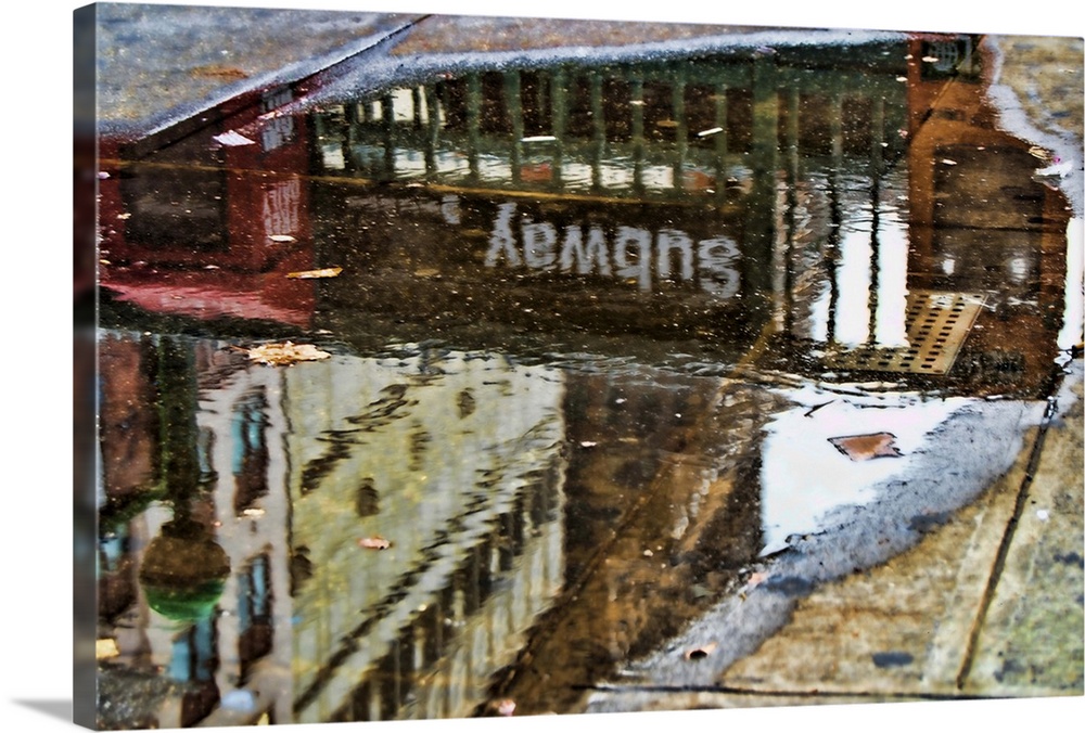 Reflections in a puddle of water showing 34th Street subway station. HDR.