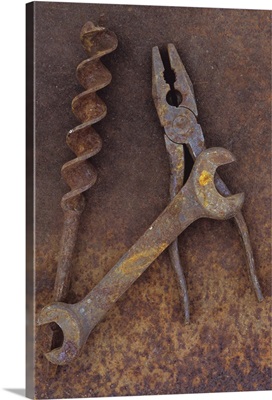 Rusty old double-headed spanner next to large drill bit and rusty pliers metal sheet II