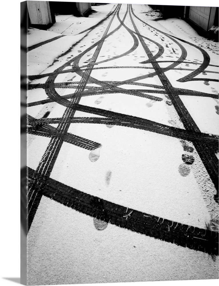 Tire tracks and foot prints in light snow.