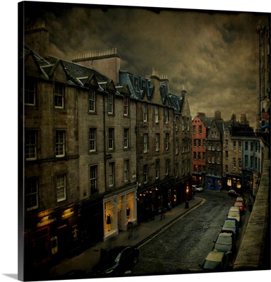Stormy skies over a town street with cars and shops