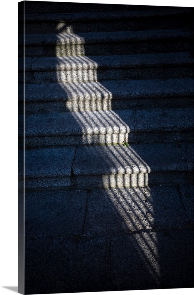 The shadow of a window grille on stone steps, Caceres, Spain