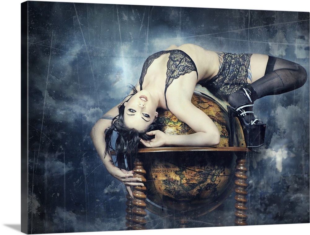 A dark haired woman in black and gold lingerie, stockings, and heels lays draped across an antique globe. The globe floats...