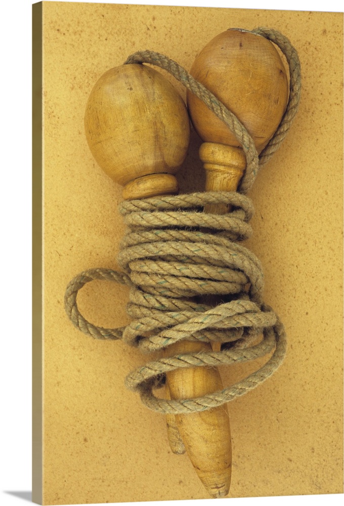 Close up of traditional skipping rope with carved and turned wooden handles lying on antique paper