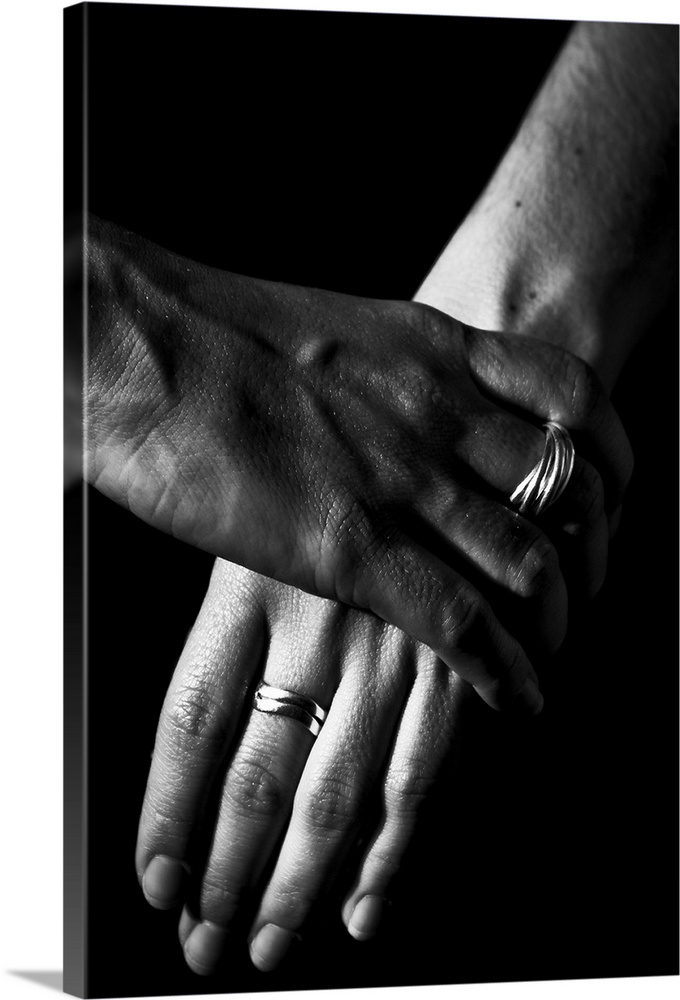Two women's hands, over a black background