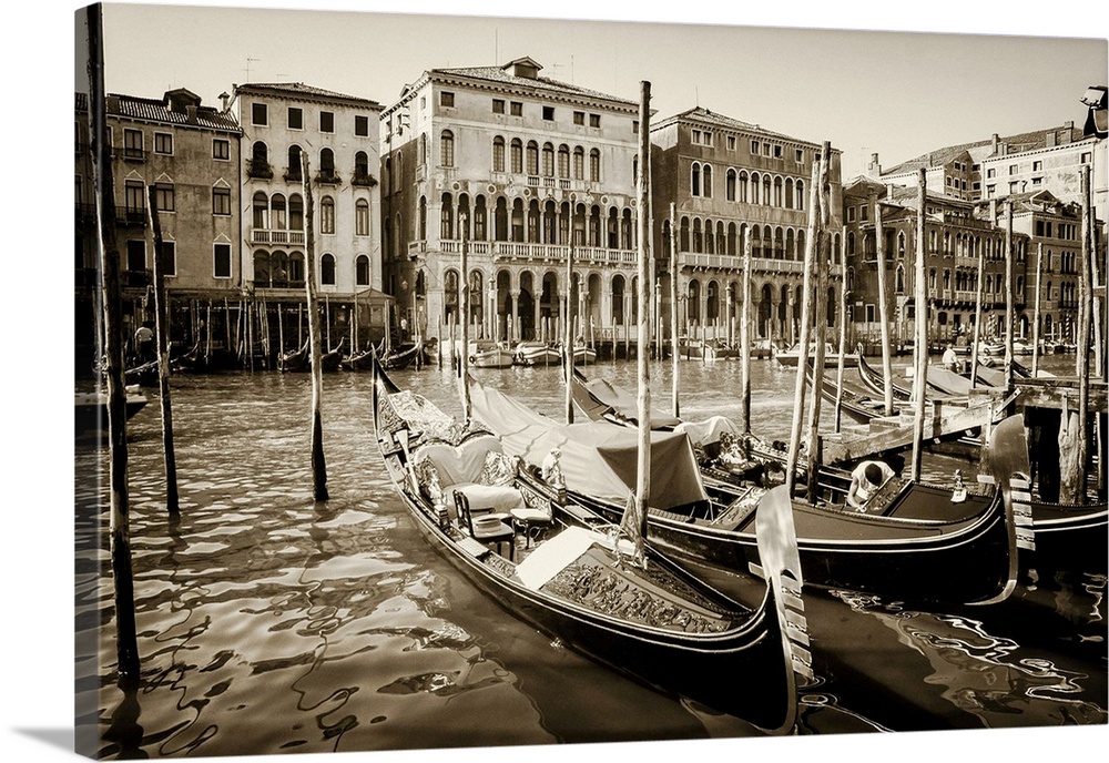 Close up of gondolas on the grand canal in Venice, Italy in summer with buildings lining the waterfront.