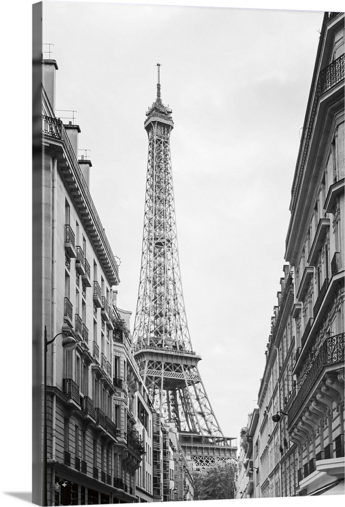 Black and white photograph of the Eiffel tower seen from street level in Paris.