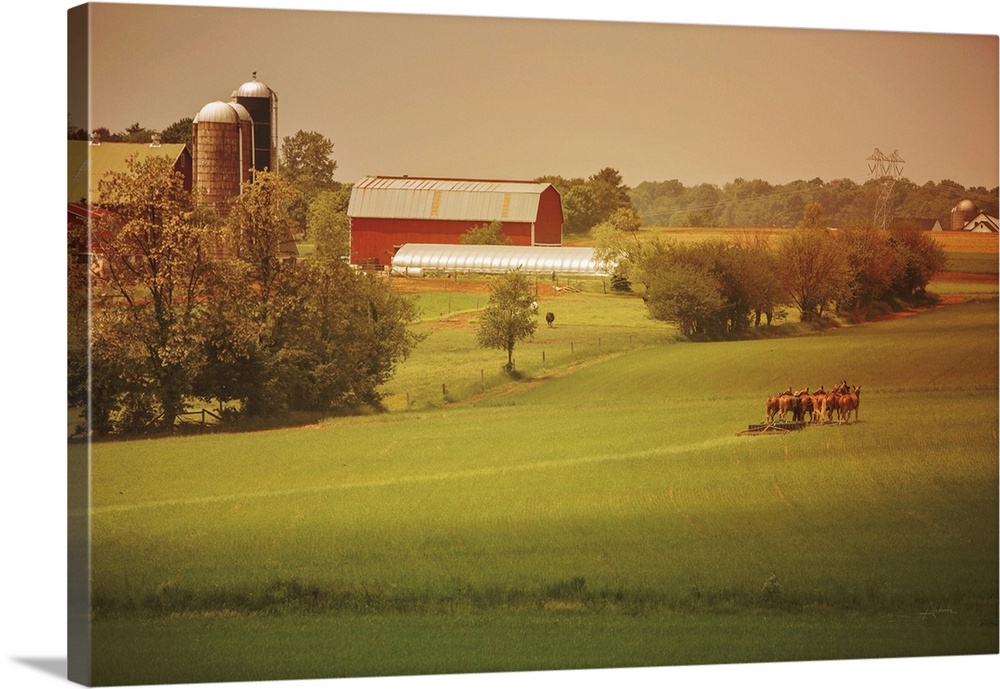 Warm photograph of a farm scene, a tractor working in a field and a red barn in the background.
