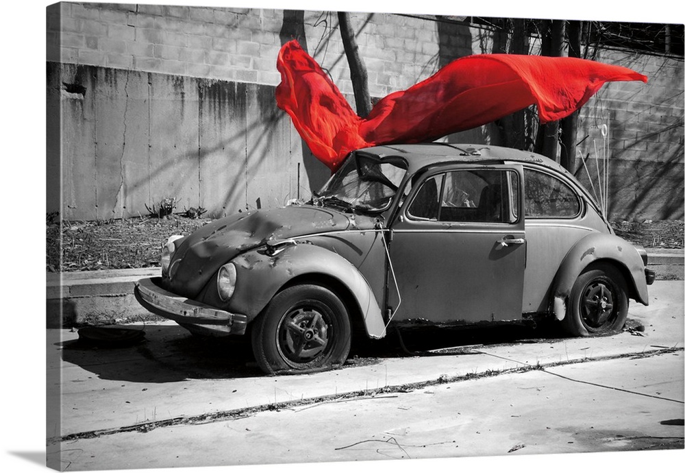 A black and white photograph of a car with a colorized red cloth hanging in the air.