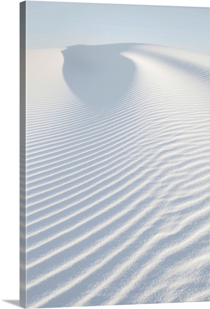 A vertical photograph of ripples in the sand dunes created by the wind.