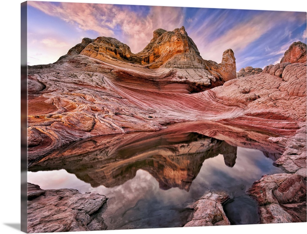 Rock formations in the Arizona desert under a sky in pink and blue sunset light.