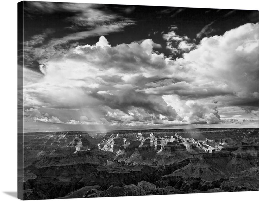 Striking black and white photograph of light shining down on a canyon.