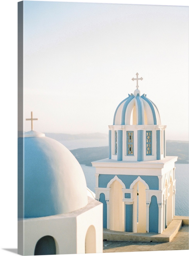 Photograph of simple church buildings with blue domed roofs, Santorini, Greece.