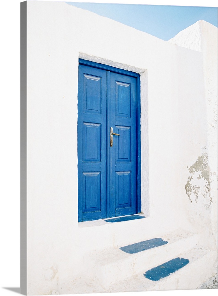 Photograph of a pair of doors and steps painted in the iconic shade of blue that Santorini, Greece is famous for.