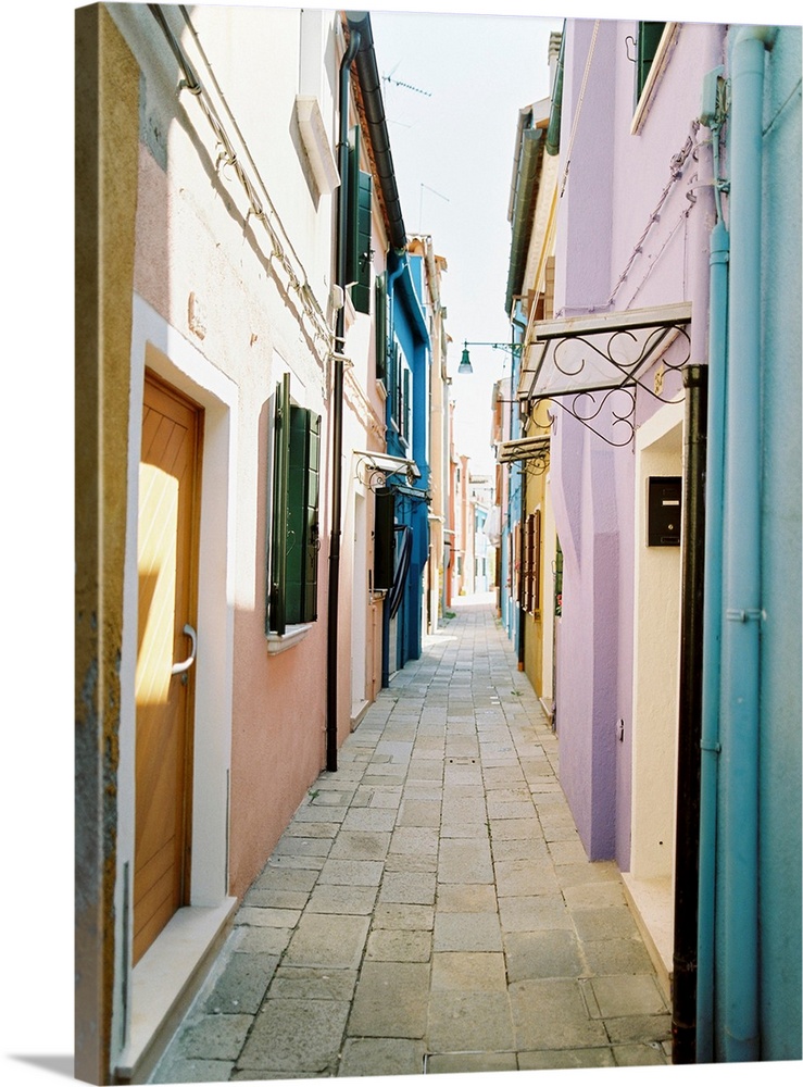 Photograph of brightly painted houses in a narrow alleyway, Burano, Italy.