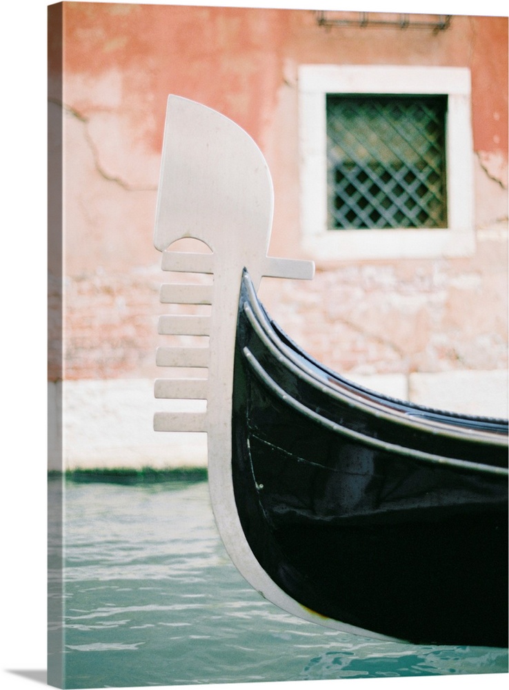 Photograph of the decoration on the end of a gondola on a canal in Venice, Italy.