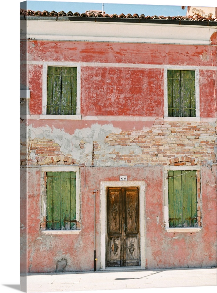 Photograph of a very old building with green shutters and pink walls, Burano, Italy.