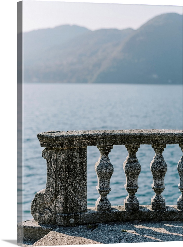 A photograph of an ornate stone balcony on the shore of Lake Como, Italy.