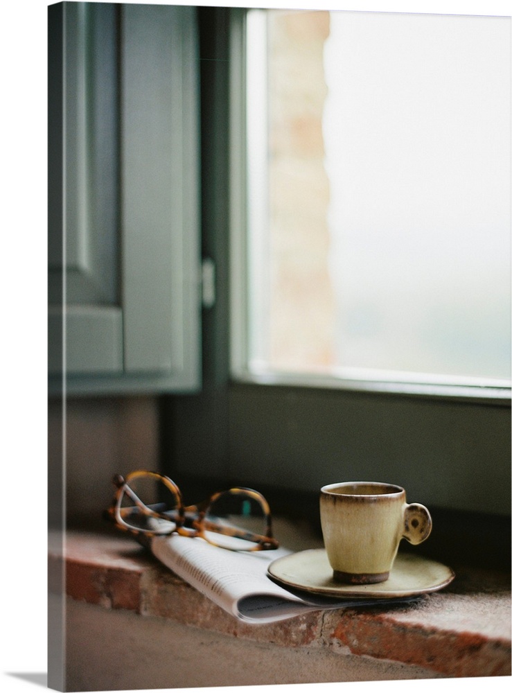 Photograph of a magazine, reading glasses and a cup of coffee on a windowsill, Tuscany, Italy.