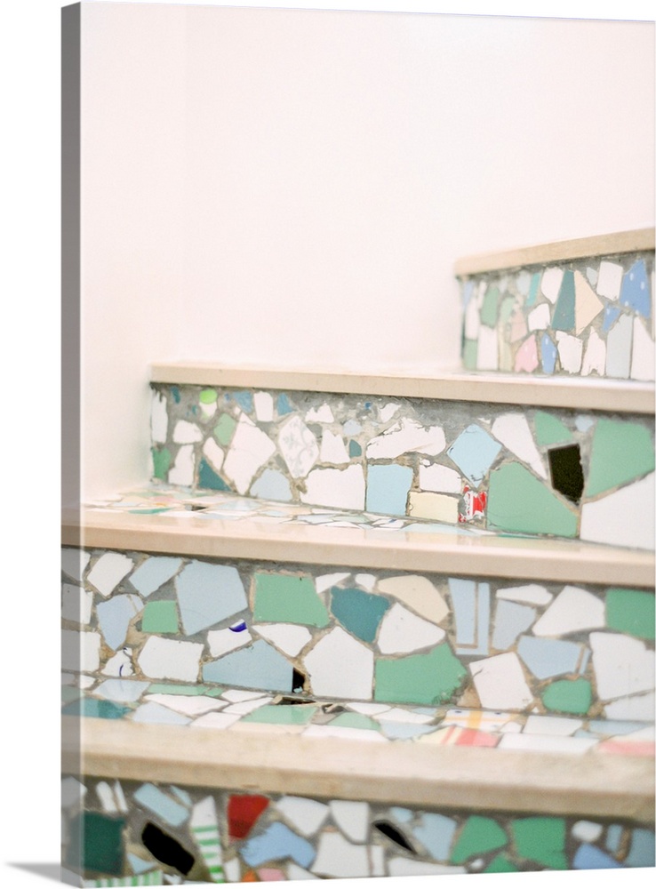 A colorful photograph of mediterranean stair risers decorated with multicolored mosaic tile fragments.