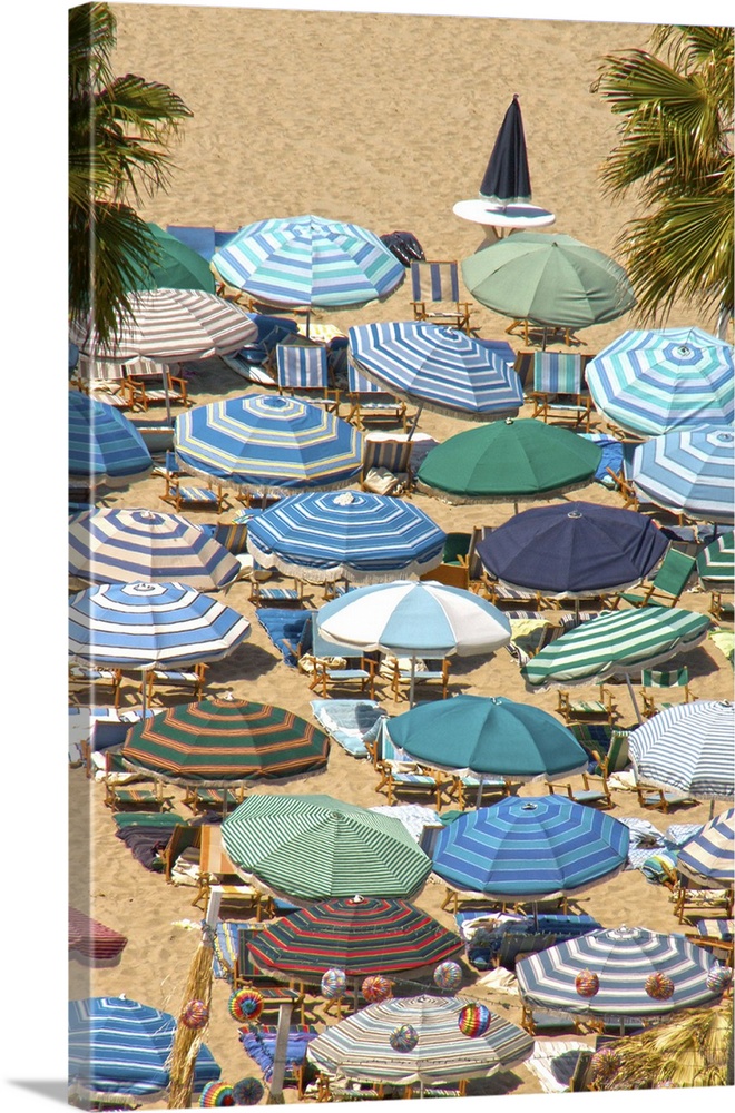 Photograph of rows of beach umbrellas in solids and stripes, mostly in blue and green.