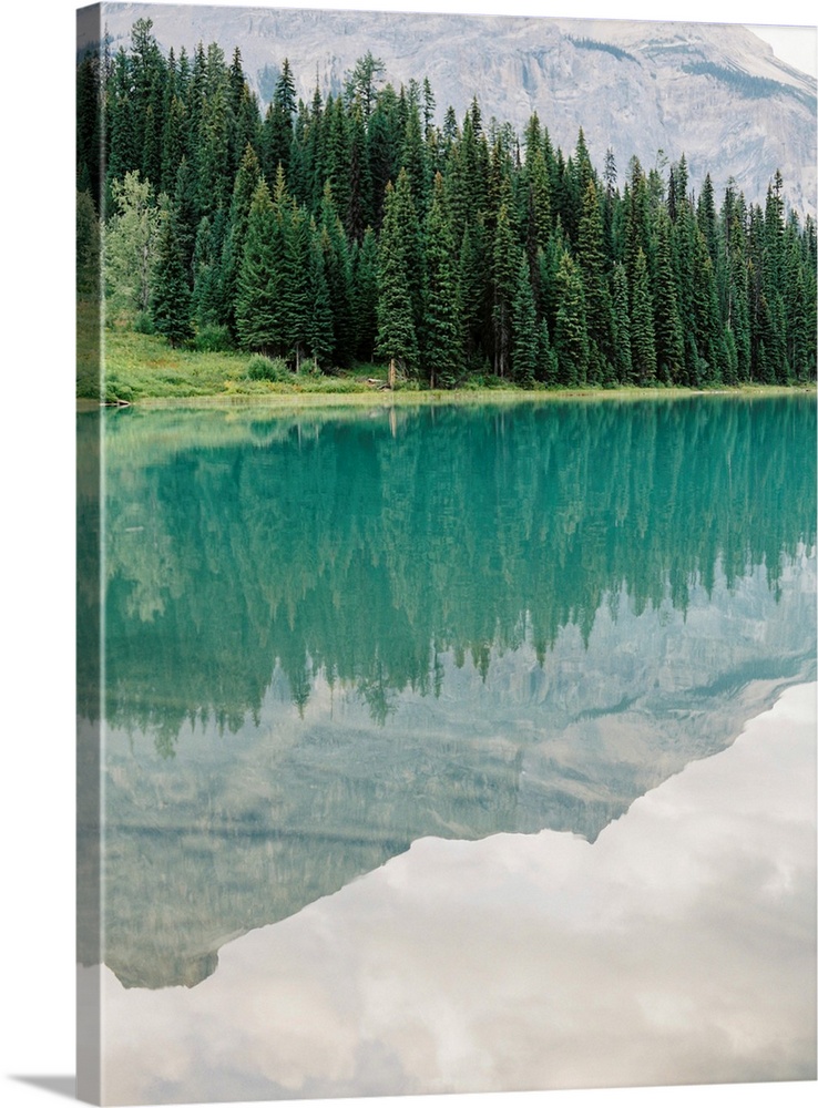 Photograph of mountains reflected in the glassy surface of Moraine Lake, Emerald Lake Lodge, Banff, Canada.