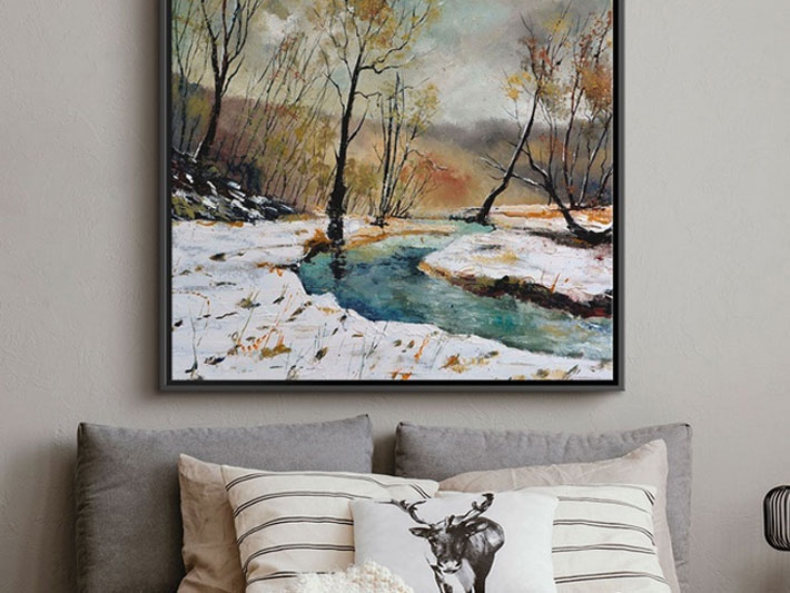 a framed canvas print on a wall over some pillows