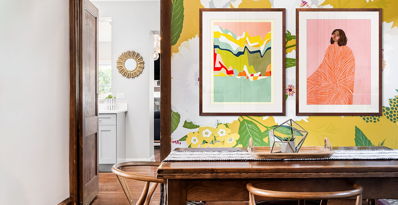 two framed prints of maximalist art in a colorful wood and yellow floral dining room